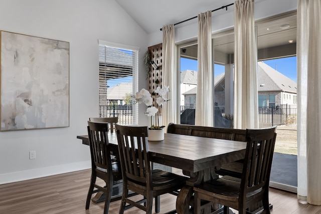 dining space featuring hardwood / wood-style flooring and vaulted ceiling