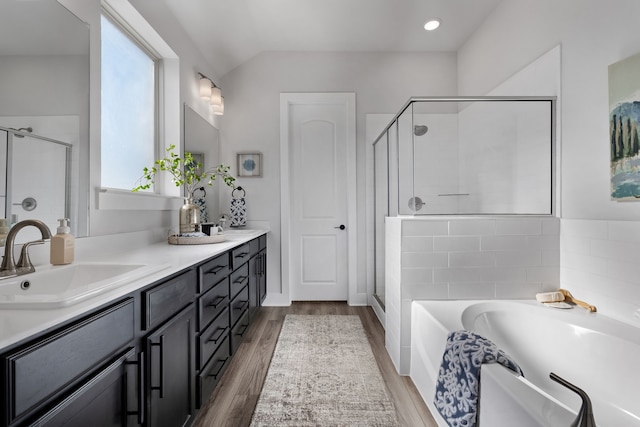 bathroom with plus walk in shower, wood-type flooring, vanity, and vaulted ceiling