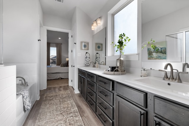 bathroom with vanity, a bath, and hardwood / wood-style flooring