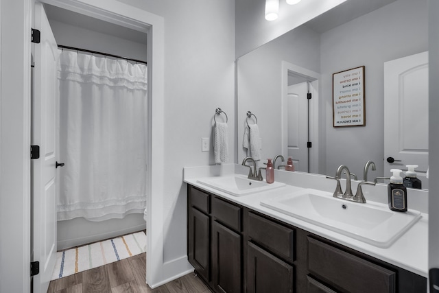 bathroom with hardwood / wood-style floors, vanity, and shower / tub combo