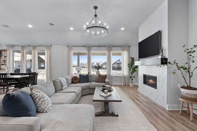 living room featuring a chandelier and light wood-type flooring