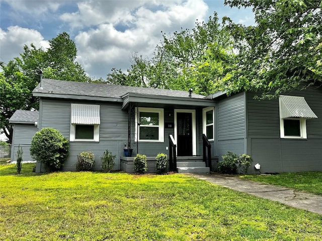view of front of property featuring a shingled roof and a front yard