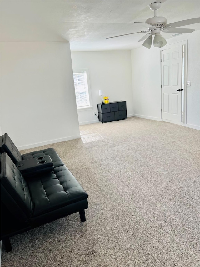 living area featuring light carpet and ceiling fan