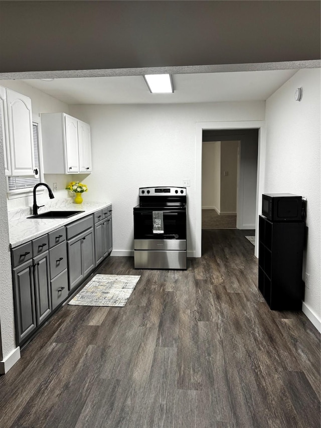 kitchen with sink, gray cabinetry, white cabinets, stainless steel range with electric cooktop, and dark hardwood / wood-style flooring