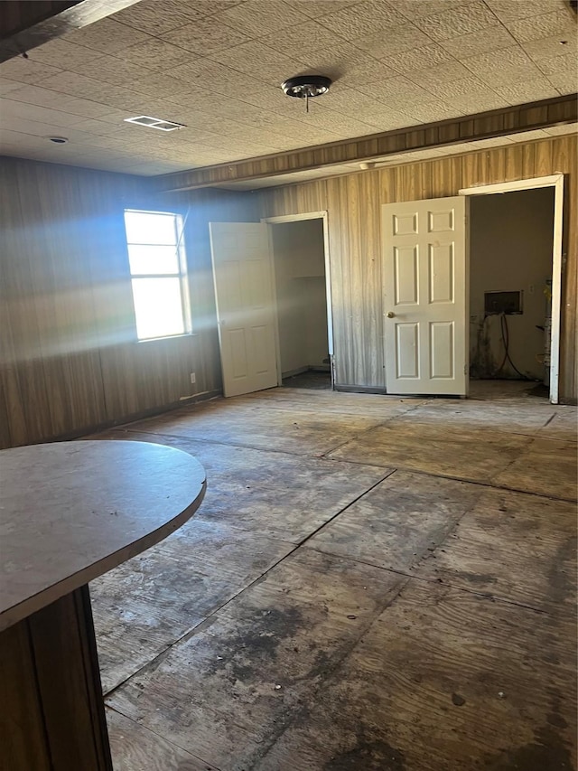 unfurnished room featuring wooden walls