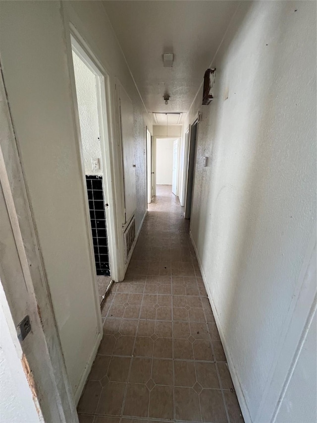 hall with dark tile patterned floors