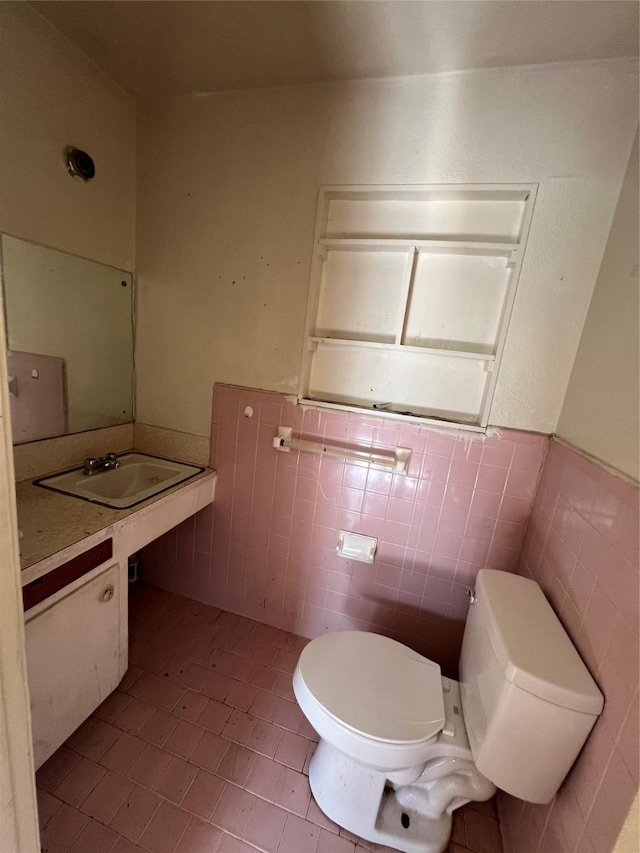 bathroom featuring tile patterned floors, vanity, toilet, and tile walls