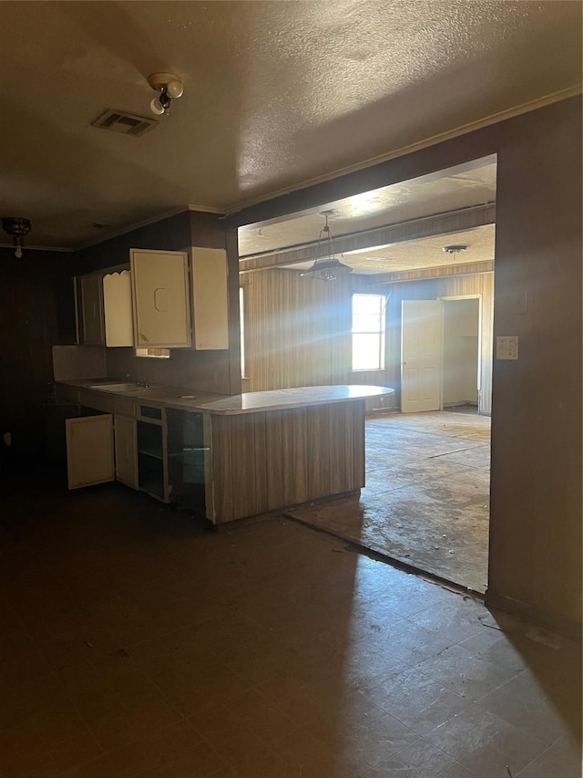 kitchen featuring crown molding and a textured ceiling