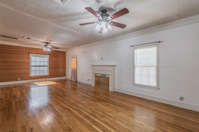 unfurnished living room with hardwood / wood-style flooring, ceiling fan, crown molding, and a textured ceiling