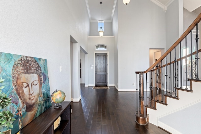 foyer with a high ceiling, dark hardwood / wood-style flooring, and ornamental molding