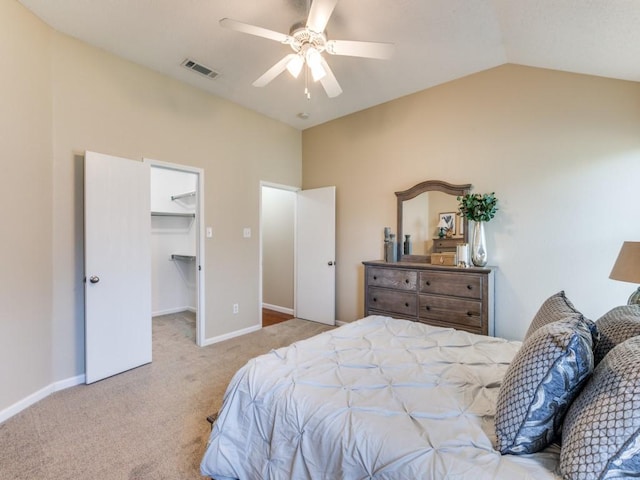 carpeted bedroom featuring a walk in closet, a closet, ceiling fan, and lofted ceiling