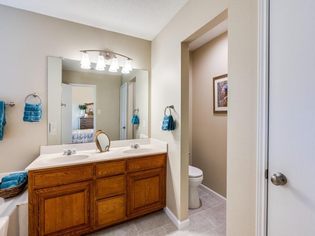 bathroom featuring tile patterned flooring, a textured ceiling, vanity, and toilet