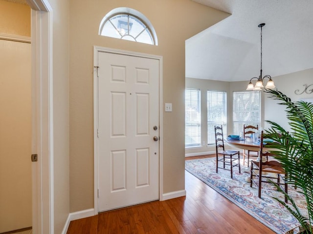 foyer with hardwood / wood-style flooring and an inviting chandelier