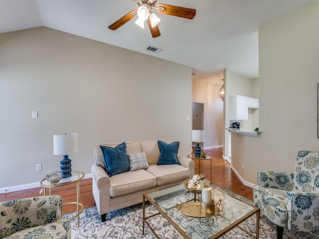 living room featuring ceiling fan, light wood-type flooring, and lofted ceiling