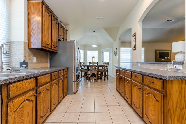 kitchen with pendant lighting, sink, stainless steel fridge, tasteful backsplash, and light tile patterned flooring