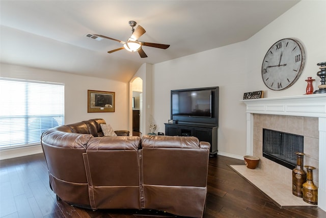 living room with a tile fireplace, dark hardwood / wood-style flooring, ceiling fan, and lofted ceiling