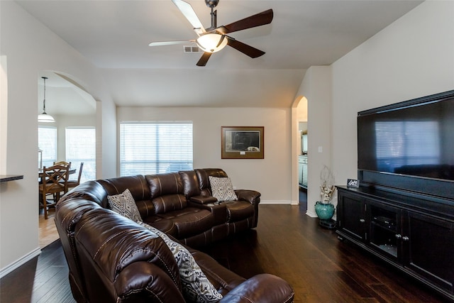 living room featuring ceiling fan and dark hardwood / wood-style flooring