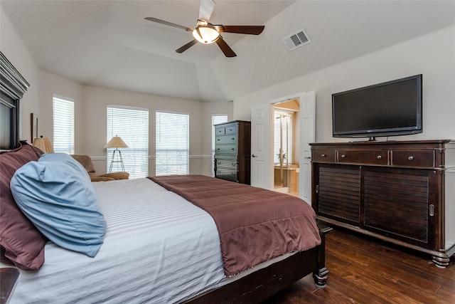 bedroom with ensuite bath, ceiling fan, dark wood-type flooring, lofted ceiling, and a tray ceiling