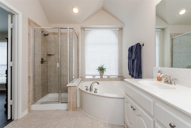 bathroom featuring plus walk in shower, vanity, a wealth of natural light, and lofted ceiling