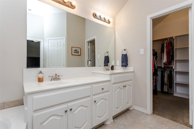 bathroom with tile patterned floors, vanity, and vaulted ceiling