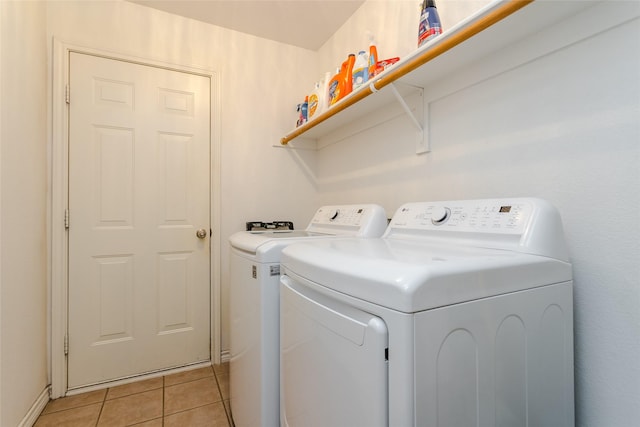 clothes washing area featuring washer and clothes dryer and light tile patterned flooring