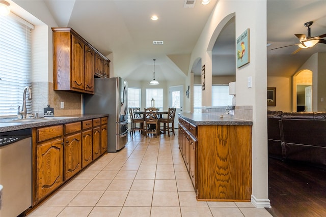 kitchen featuring ceiling fan, sink, stainless steel appliances, backsplash, and light tile patterned floors