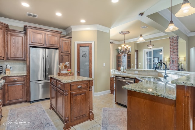 kitchen featuring stainless steel appliances, sink, a notable chandelier, a center island, and hanging light fixtures