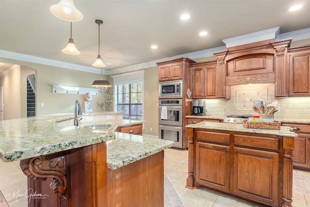 kitchen with appliances with stainless steel finishes, tasteful backsplash, a spacious island, sink, and decorative light fixtures