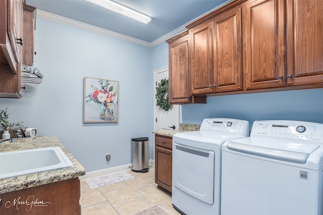 laundry area with washer and clothes dryer, cabinets, sink, ornamental molding, and light tile patterned floors