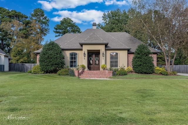 view of front facade featuring french doors and a front lawn