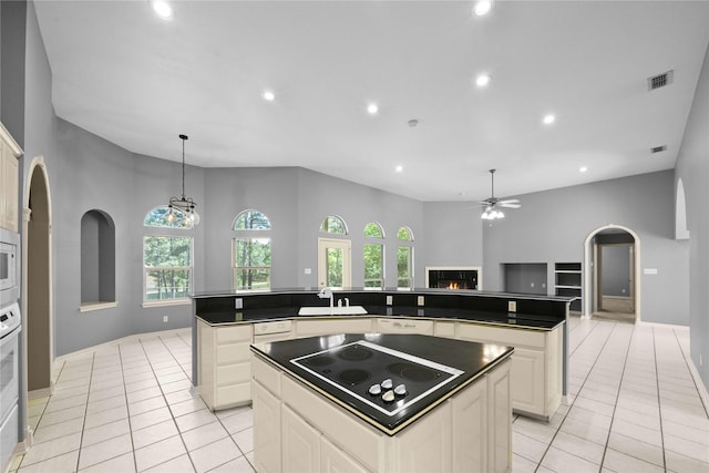 kitchen with light tile patterned floors, white appliances, and a kitchen island