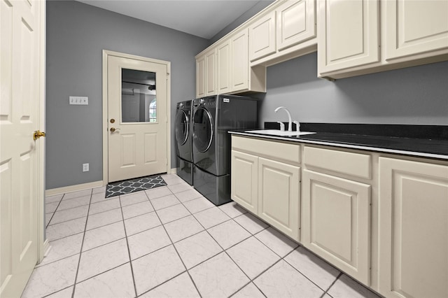 laundry room with cabinets, light tile patterned floors, washer and dryer, and sink