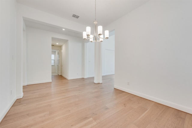 unfurnished dining area featuring light hardwood / wood-style flooring and an inviting chandelier