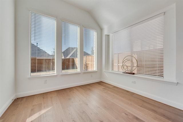 unfurnished room featuring light wood-type flooring and lofted ceiling