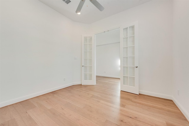 empty room with ceiling fan, french doors, and light wood-type flooring