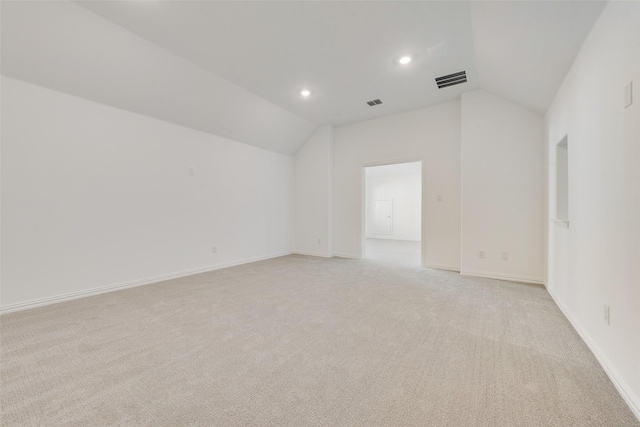 carpeted empty room featuring vaulted ceiling