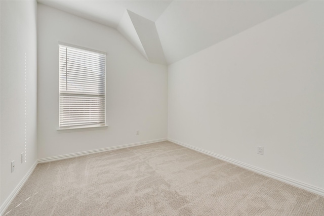 spare room with lofted ceiling and light carpet