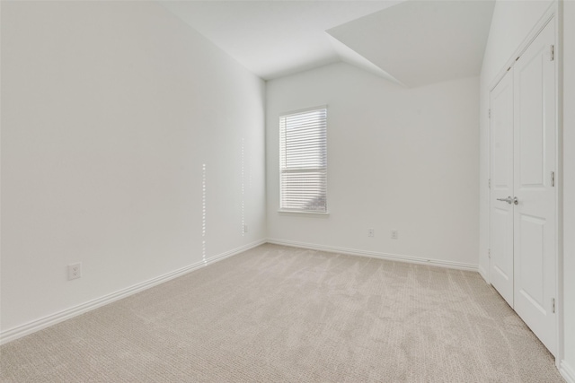 unfurnished bedroom with light carpet and vaulted ceiling