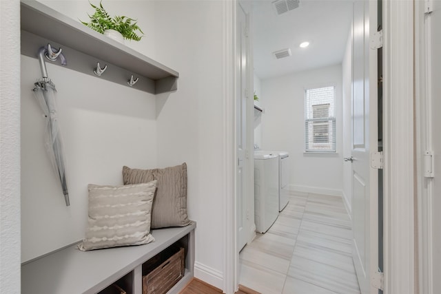 mudroom featuring separate washer and dryer and light tile patterned flooring