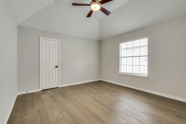 spare room with light hardwood / wood-style floors, a raised ceiling, ceiling fan, and lofted ceiling