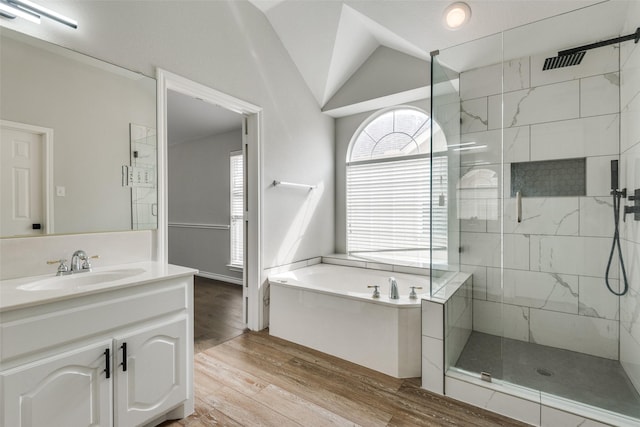 bathroom featuring vanity, wood-type flooring, lofted ceiling, and shower with separate bathtub