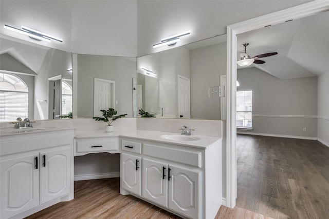 bathroom with vanity, hardwood / wood-style flooring, and vaulted ceiling