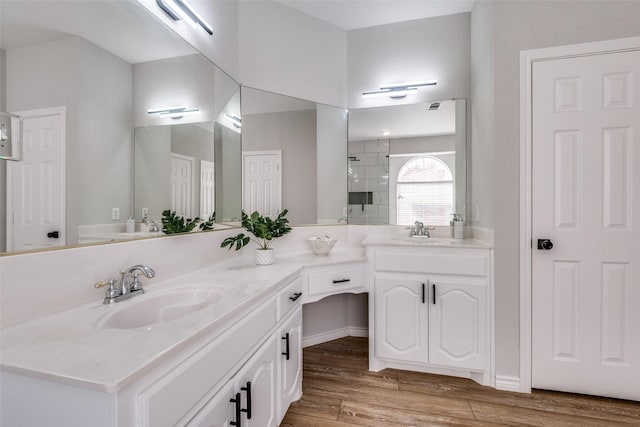 bathroom featuring hardwood / wood-style floors, vanity, and walk in shower