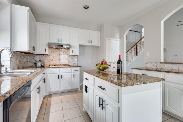 kitchen featuring sink, exhaust hood, stone countertops, dishwasher, and white cabinetry