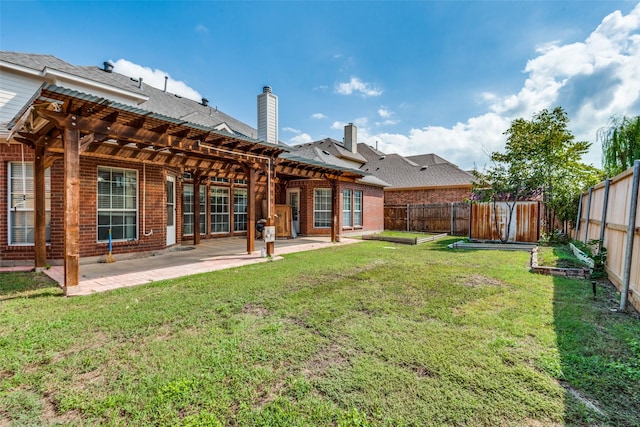 rear view of house with a yard, a pergola, and a patio area