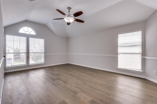 empty room with hardwood / wood-style flooring, ceiling fan, and lofted ceiling