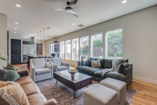 living room featuring ceiling fan and light wood-type flooring