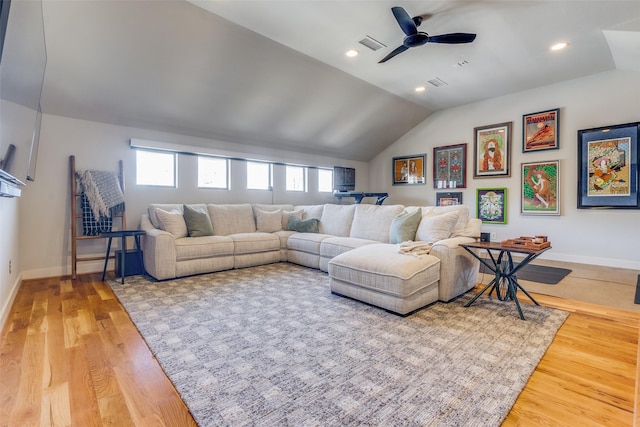 living room with hardwood / wood-style flooring, ceiling fan, and vaulted ceiling