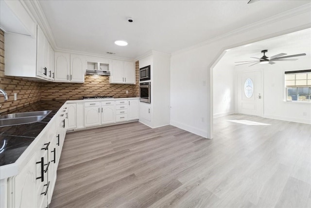 kitchen with ceiling fan, sink, stainless steel appliances, tasteful backsplash, and white cabinets