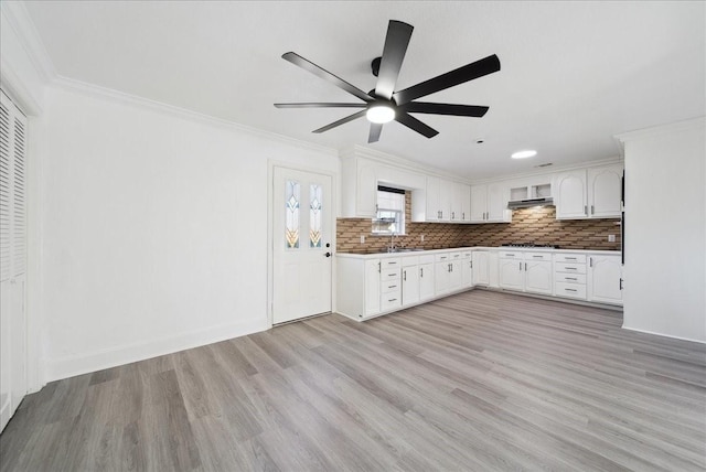 kitchen featuring white cabinetry, crown molding, light hardwood / wood-style flooring, and sink